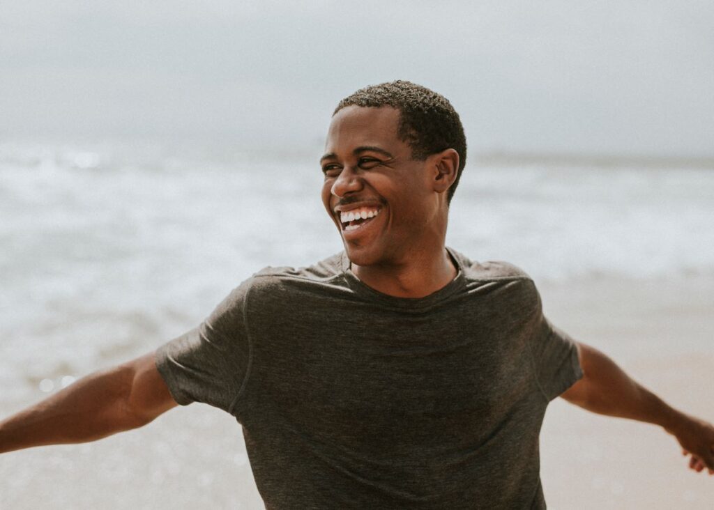 A man smiling on the beach.